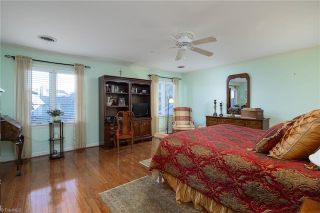 bedroom featuring ceiling fan, wood-type flooring, and ornamental molding