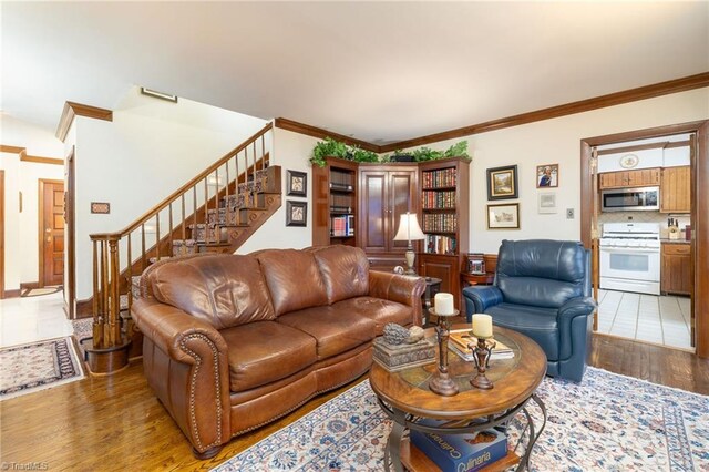 living room with ornamental molding and hardwood / wood-style floors