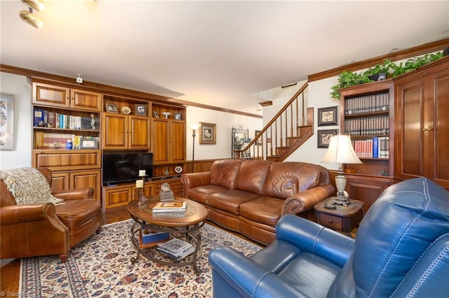 living room with ornamental molding and wood walls