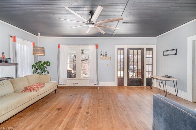 living area featuring french doors, crown molding, ceiling fan, and wood finished floors