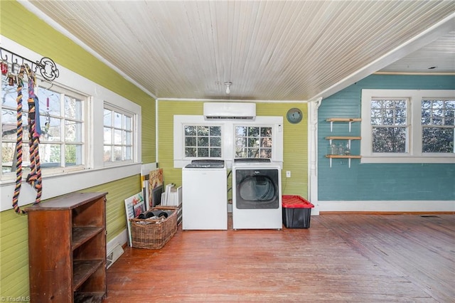 laundry area featuring a wall unit AC, wood finished floors, and independent washer and dryer