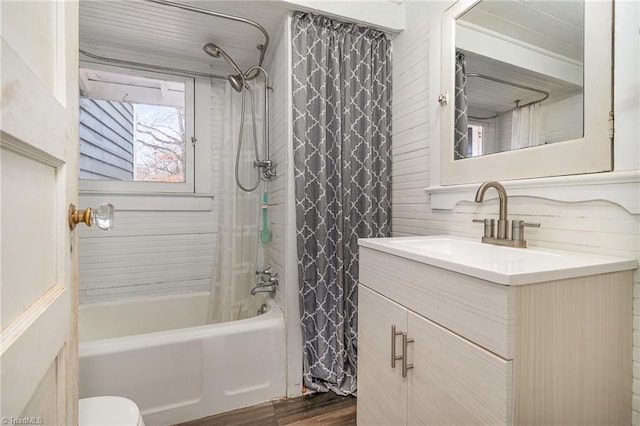 full bath with shower / tub combo with curtain, wood finished floors, vanity, and toilet