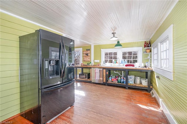 kitchen featuring black fridge with ice dispenser, wood finished floors, wooden ceiling, wood walls, and dishwasher