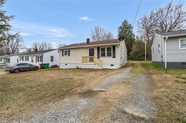 view of front facade featuring crawl space, driveway, a chimney, and a front lawn