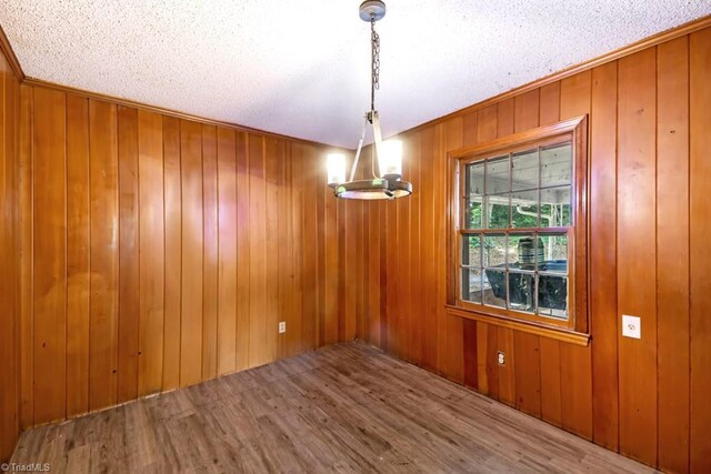 1281 Woodbrook Dr, Kernersville, NC 27284 - unfurnished dining area featuring wood finished floors, ornamental molding, a textured ceiling, and wooden walls