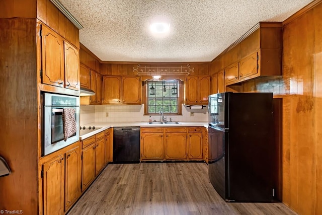 1281 Woodbrook Dr, Kernersville, NC 27284 - kitchen featuring black appliances, a sink, a textured ceiling, brown cabinetry, and backsplash