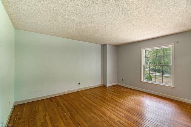 1281 Woodbrook Dr, Kernersville, NC 27284 - unfurnished room with a textured ceiling, hardwood / wood-style floors, and baseboards