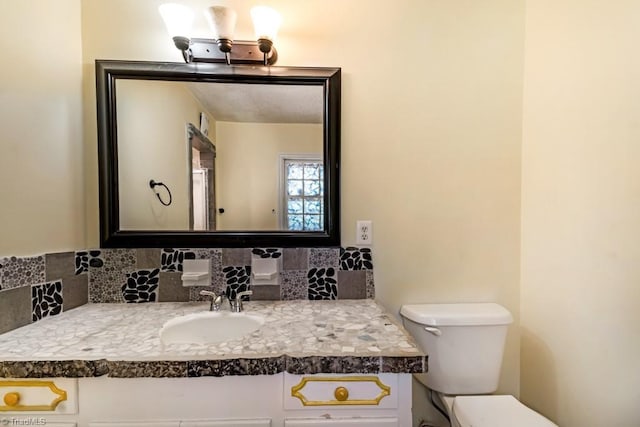 1281 Woodbrook Dr, Kernersville, NC 27284 - half bathroom featuring toilet, vanity, and tasteful backsplash