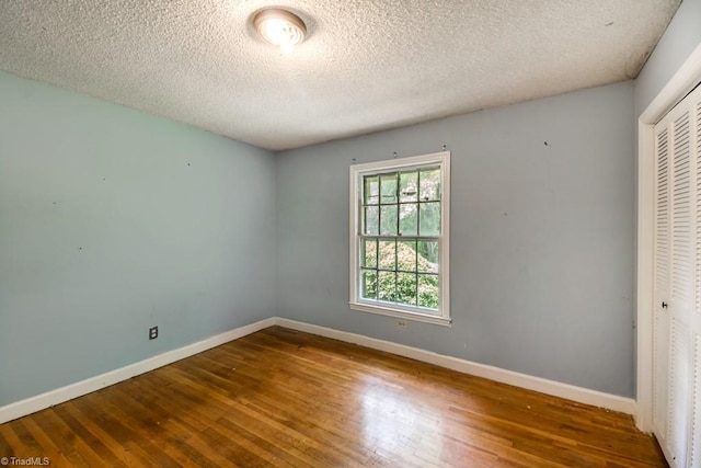 1281 Woodbrook Dr, Kernersville, NC 27284 - unfurnished bedroom with a closet, hardwood / wood-style flooring, baseboards, and a textured ceiling