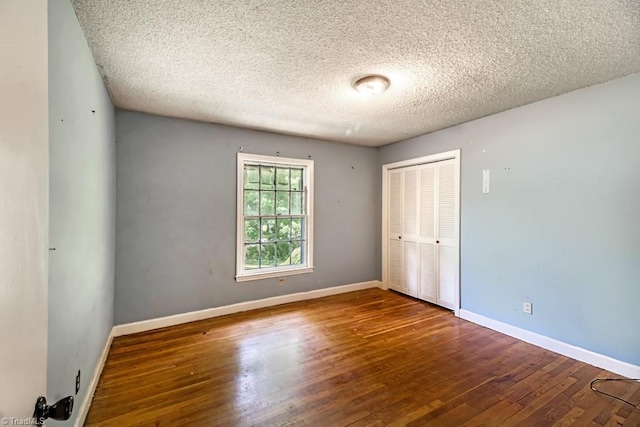 1281 Woodbrook Dr, Kernersville, NC 27284 - unfurnished bedroom with a closet, hardwood / wood-style floors, a textured ceiling, and baseboards