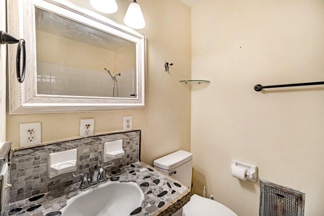 1281 Woodbrook Dr, Kernersville, NC 27284 - full bathroom featuring toilet, backsplash, a shower, and vanity