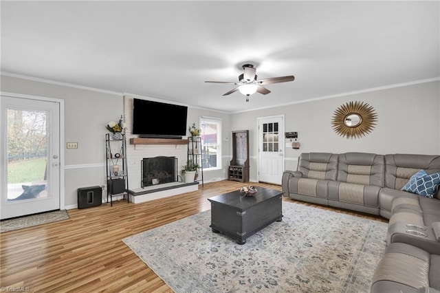 living room featuring hardwood / wood-style floors, ornamental molding, and plenty of natural light