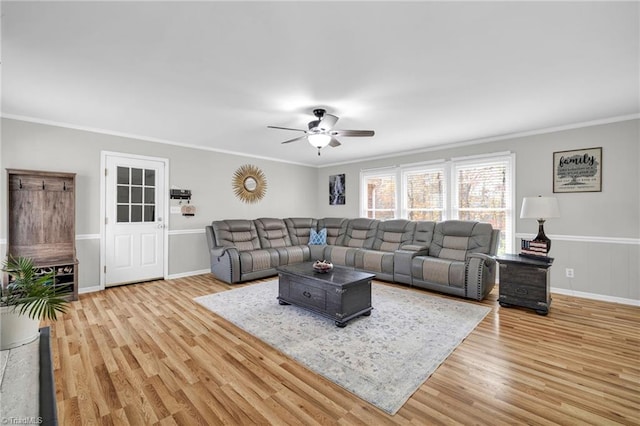 living room featuring light hardwood / wood-style flooring, ceiling fan, and crown molding