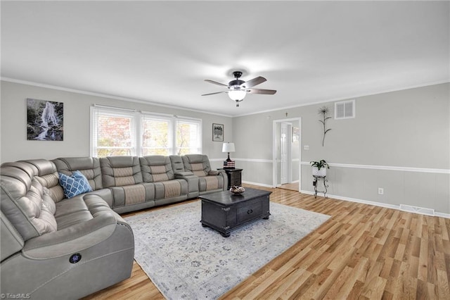 living room featuring hardwood / wood-style floors, ceiling fan, and ornamental molding