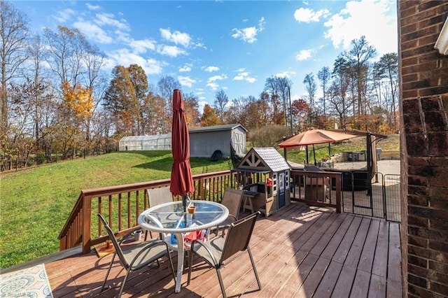 wooden deck featuring a lawn and a storage shed