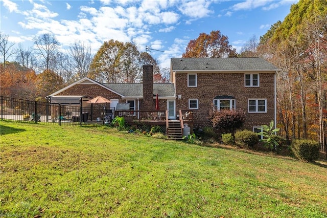 back of house featuring a lawn and a wooden deck