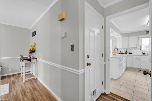 hallway with light hardwood / wood-style floors and crown molding