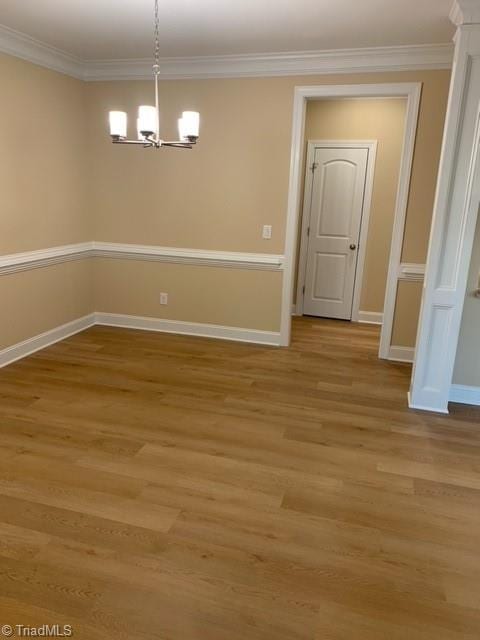 unfurnished dining area featuring ornamental molding, a notable chandelier, and light hardwood / wood-style floors