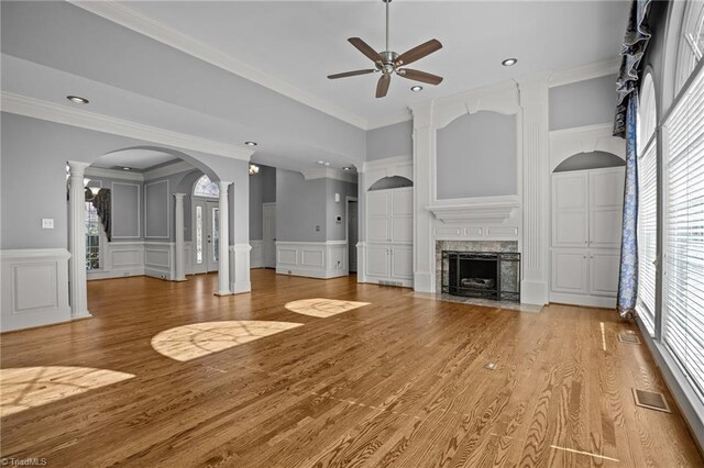 5005 Marble Arch Rd, Winston-Salem, NC 27104 - unfurnished living room with a decorative wall, ceiling fan, healthy amount of natural light, decorative columns, and crown molding