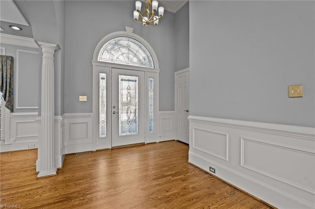 5005 Marble Arch Rd, Winston-Salem, NC 27104 - foyer entrance featuring a decorative wall, wainscoting, a chandelier, wood finished floors, and decorative columns