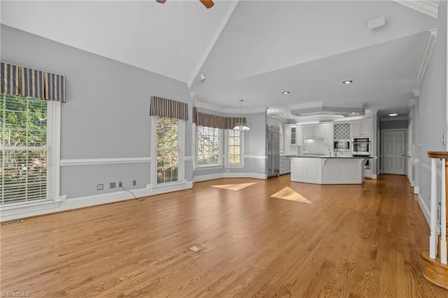 5005 Marble Arch Rd, Winston-Salem, NC 27104 - unfurnished living room with crown molding, lofted ceiling, light wood-style floors, ceiling fan, and recessed lighting