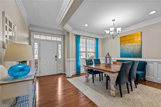 dining room with hardwood / wood-style flooring, ornamental molding, and a notable chandelier