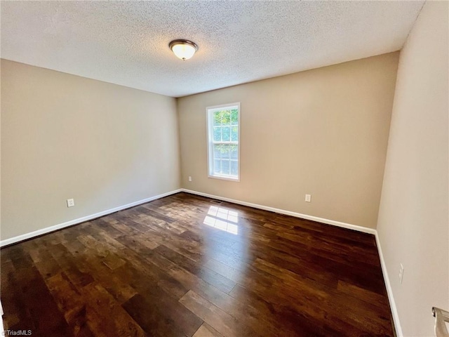 unfurnished room with hardwood / wood-style flooring, baseboards, and a textured ceiling