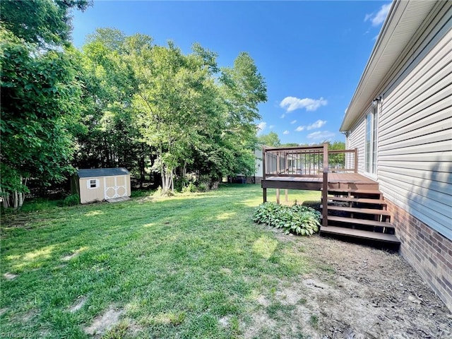 view of grassy yard featuring a storage shed, a deck, and an outdoor structure