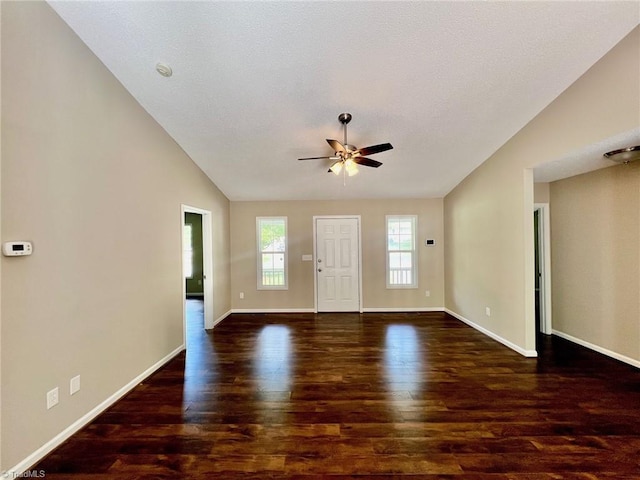 foyer entrance with wood finished floors, a ceiling fan, vaulted ceiling, and baseboards
