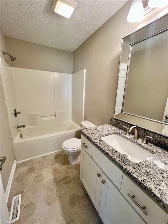 full bath with washtub / shower combination, a textured ceiling, toilet, vanity, and tile patterned floors