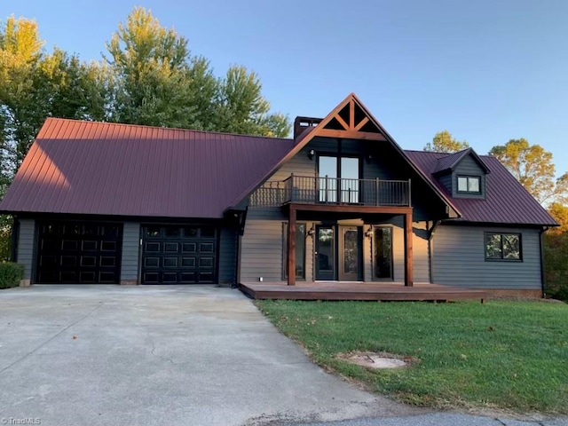 view of front of property with a garage, a front lawn, and a balcony