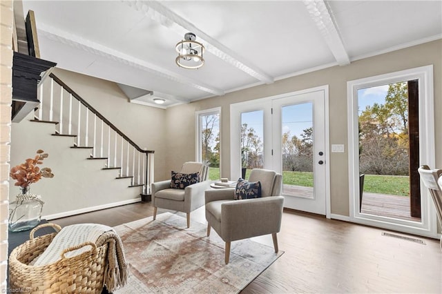 living room with a wealth of natural light, beamed ceiling, and hardwood / wood-style flooring