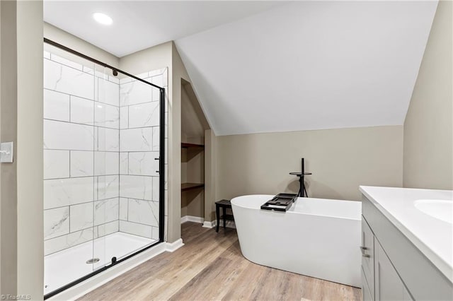 bathroom featuring hardwood / wood-style floors, independent shower and bath, vanity, and lofted ceiling