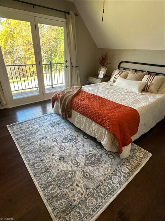 bedroom featuring access to outside, dark hardwood / wood-style floors, and vaulted ceiling