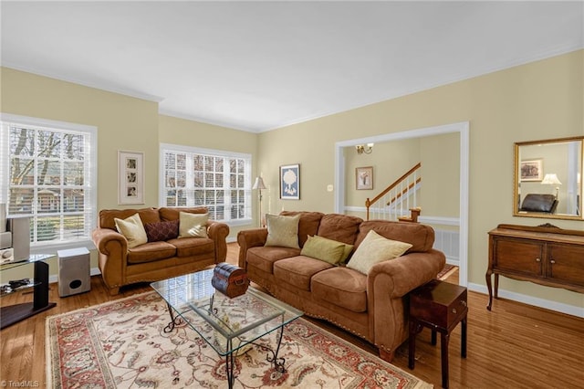 living area with crown molding, wood finished floors, and baseboards