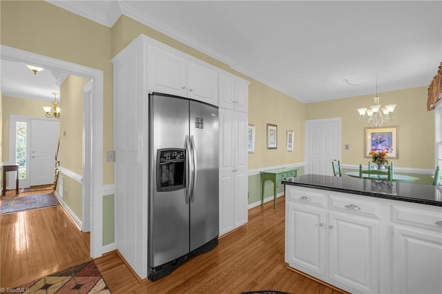 kitchen featuring white cabinets, stainless steel fridge with ice dispenser, dark countertops, wood finished floors, and an inviting chandelier