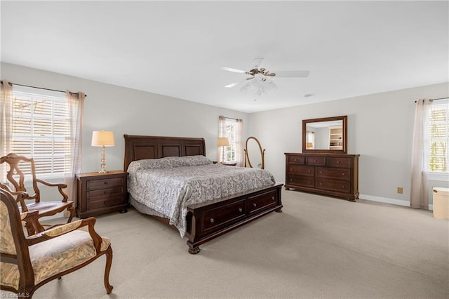 bedroom with a ceiling fan, light carpet, and baseboards