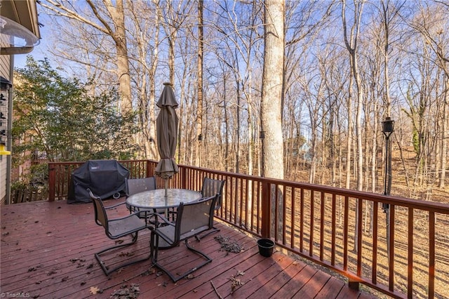 deck with a grill and outdoor dining area