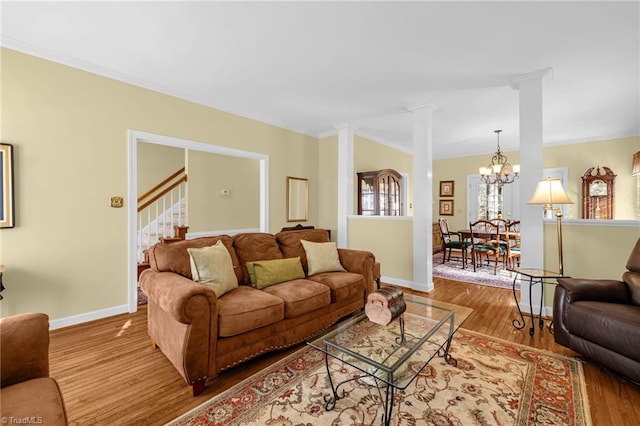 living room with ornamental molding, wood finished floors, decorative columns, and baseboards