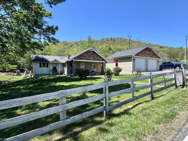 ranch-style house with fence private yard, an outdoor structure, a front lawn, and a detached garage