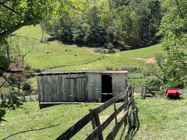 view of pole building featuring a lawn and fence