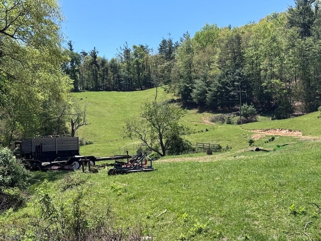 surrounding community with a lawn, a forest view, and a rural view