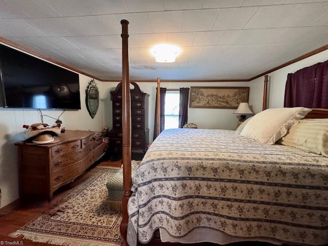 bedroom with ornamental molding and wood finished floors