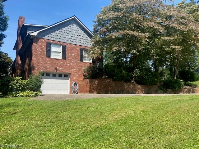 view of side of home featuring a garage and a yard