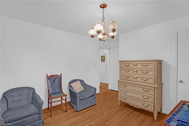 living area featuring light hardwood / wood-style floors and a chandelier