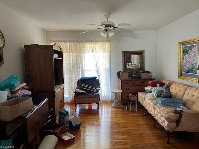 living area featuring hardwood / wood-style floors and ceiling fan