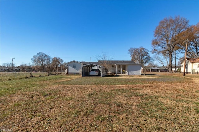 rear view of property with a carport and a yard