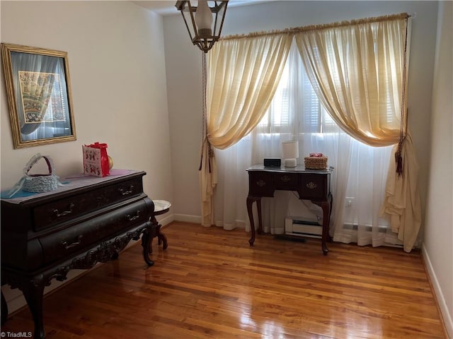 misc room with hardwood / wood-style floors and a baseboard heating unit