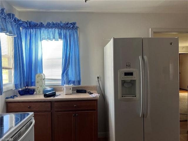 kitchen with stove and refrigerator with ice dispenser