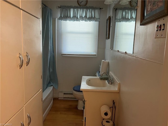 full bathroom featuring shower / bath combo, vanity, a baseboard radiator, hardwood / wood-style floors, and toilet